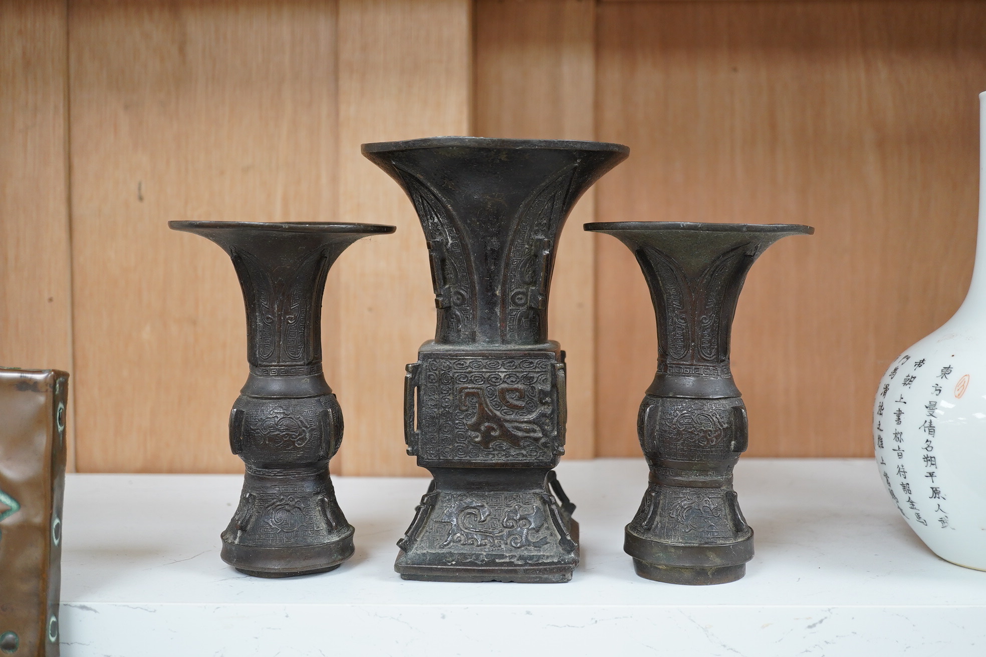 A pair 17th/18th century Chinese archaistic bronze gu vases, and a similar square vase, fanggu, Ming dynasty, tallest 18cm. Condition - poor to fair